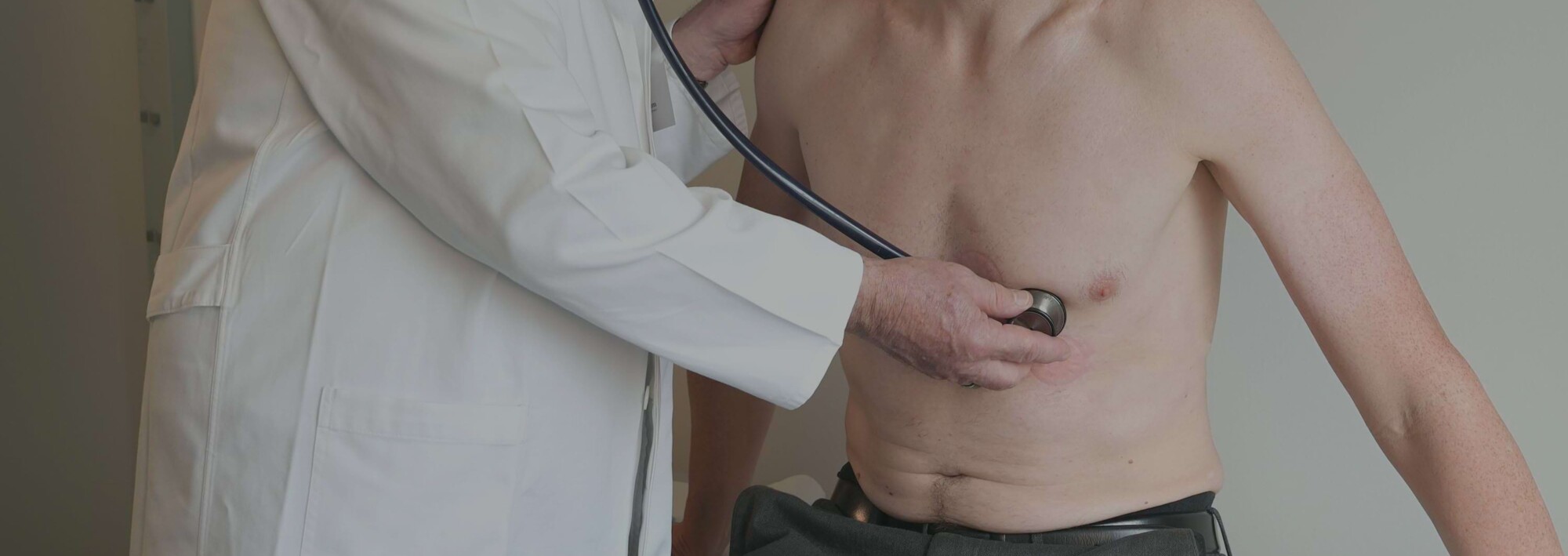 Prof. Dr. Hamm hört das Herz eines Patienten mit dem Stethoskop ab